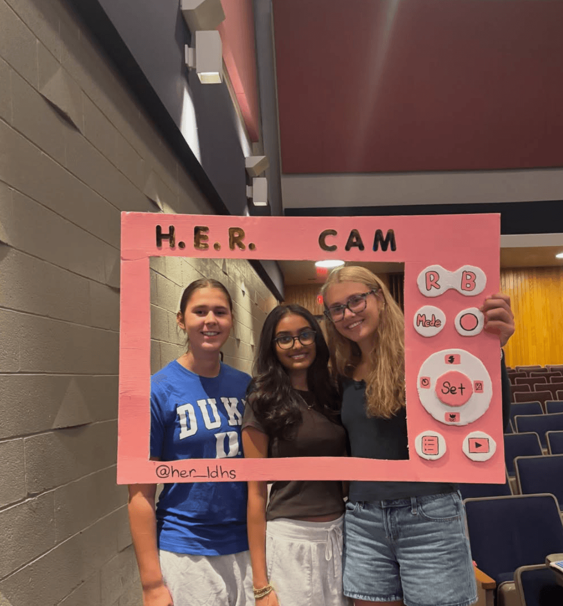 HER students posing in a H.E.R. CAM photo frame